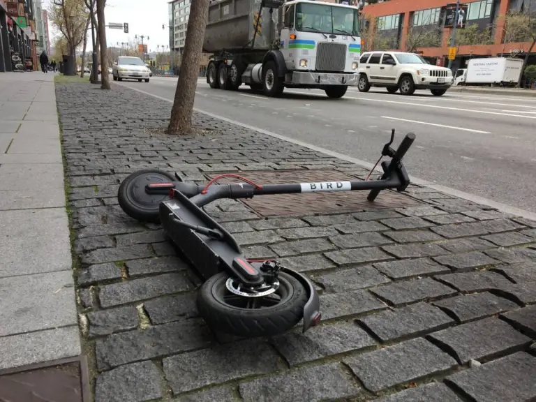 Scooter lying on sidewalk